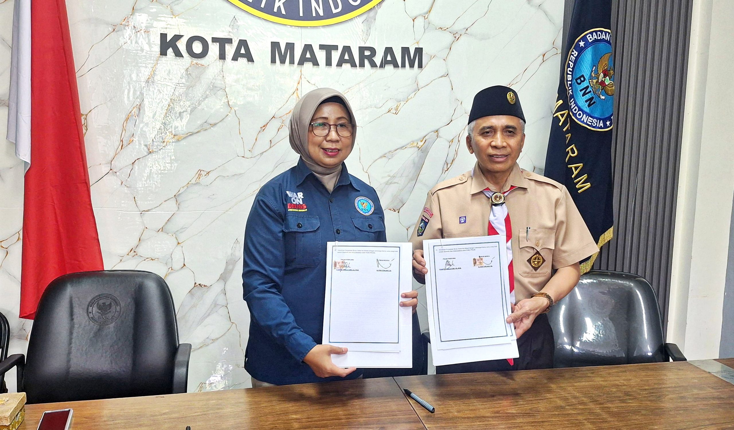 Ketua BNN Kota Mataram Kombespol Yuanita dan Ketua Kwarcab Kota Mataram, H. Didi Sumardi, SH memperlihatkan PKS pembentukan Pramuka Anti Narkoba, Kamis (23/4).